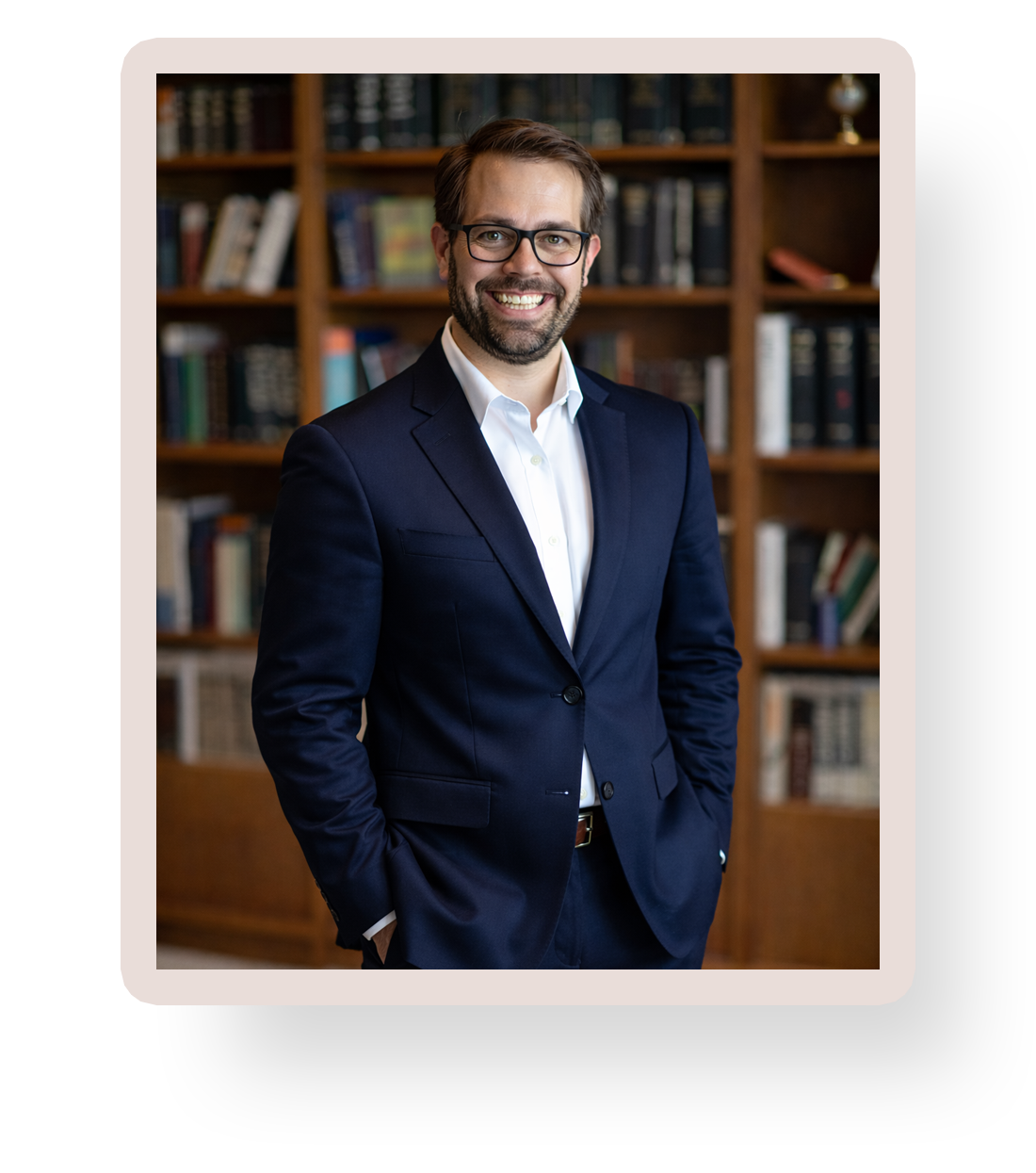 HAA Web Host Tom smiling in a library, wearing a navy suit
