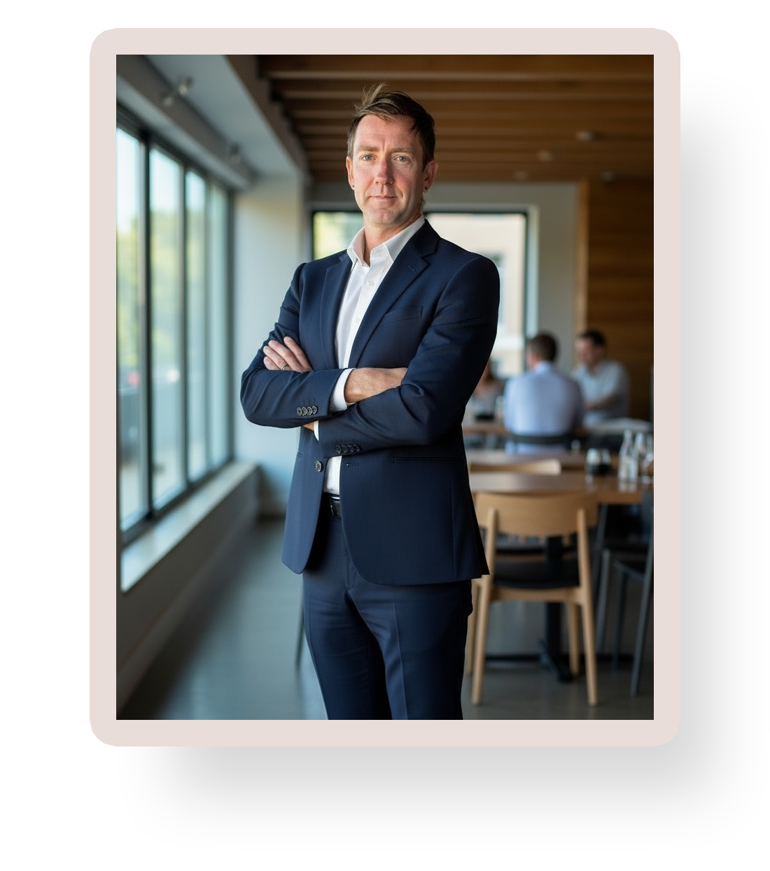 Xtian standing confidently in an office setting with arms crossed.