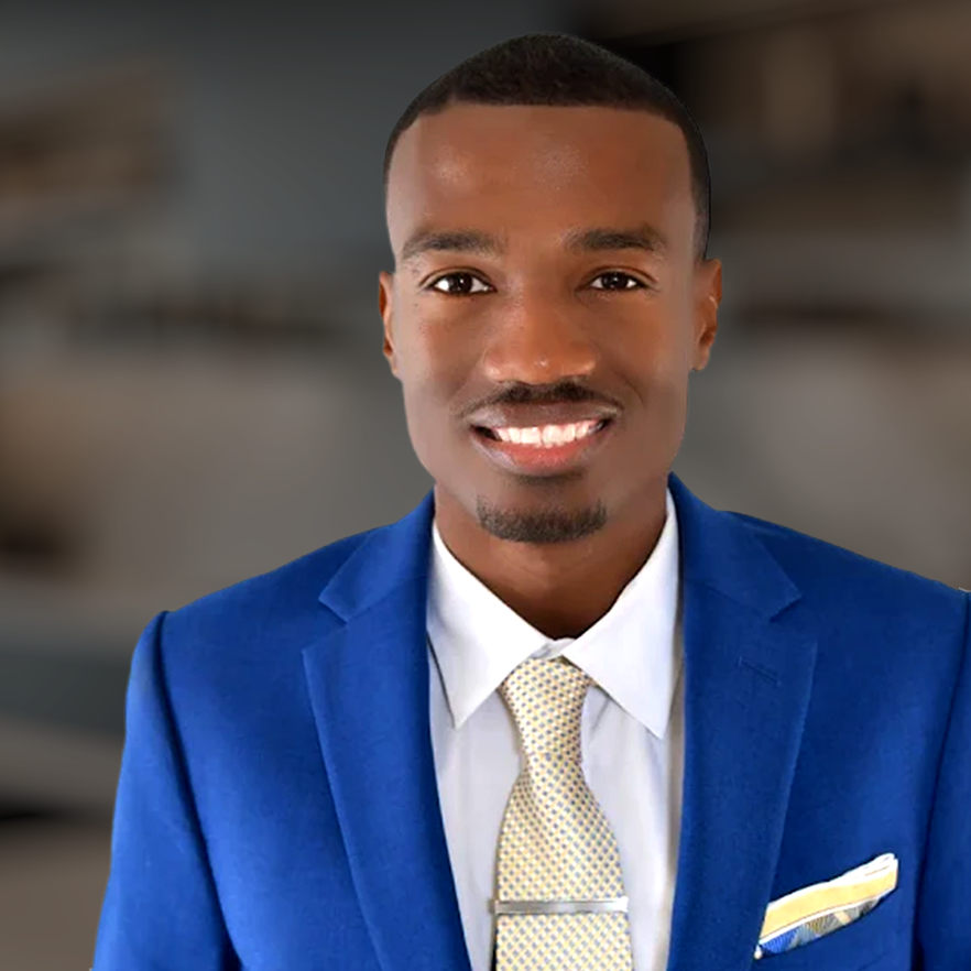RAY smiling in blue suit with light tie and pocket square